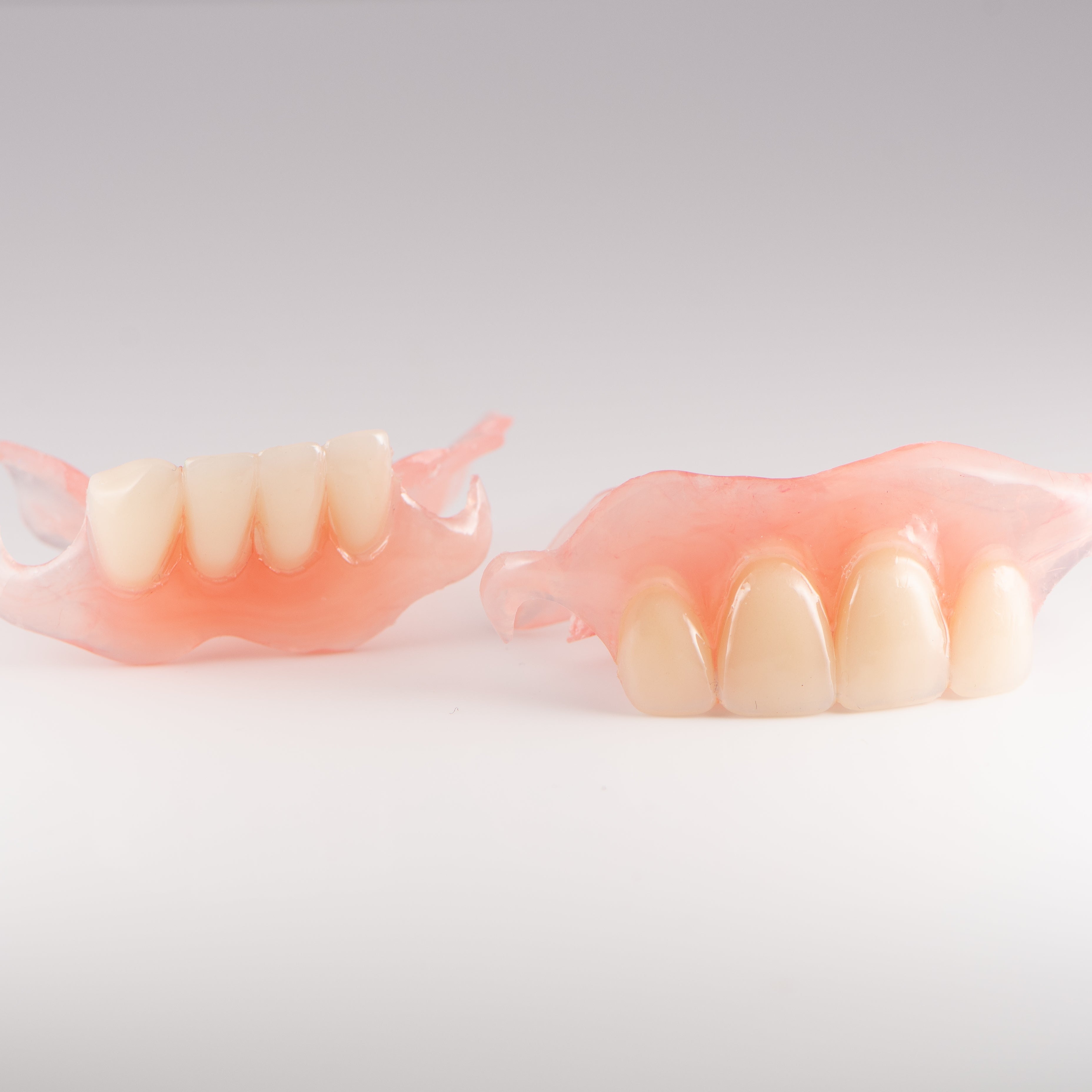 Upper and Lower Flexible Partial Denture on Gray Background