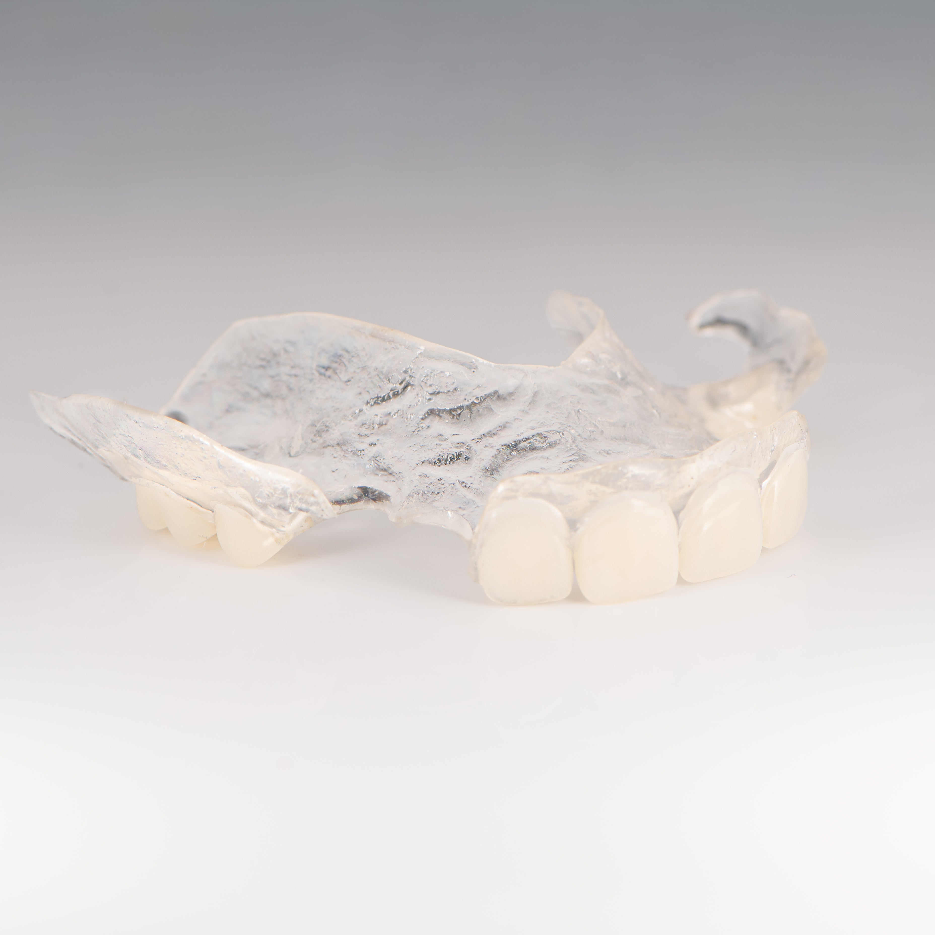 Clear Flexible Partial Denture on Gray Background