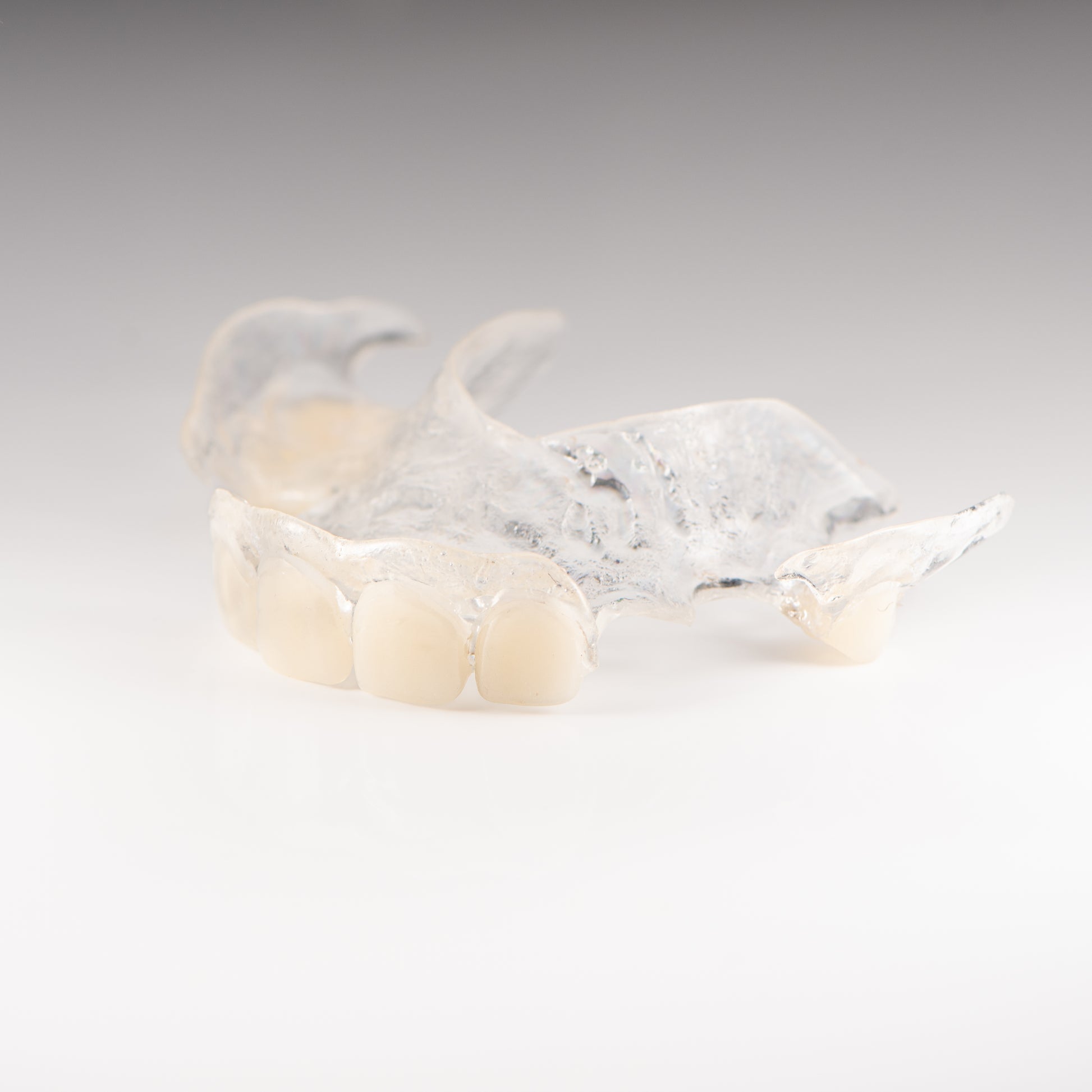 Clear Flexible Partial Denture on Gray Background